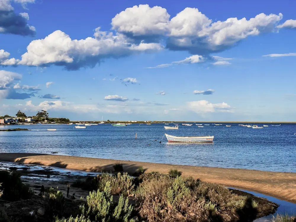 Hav, strand och båtar i Ria Formosa Naturpark under vandringsresa i Algarve